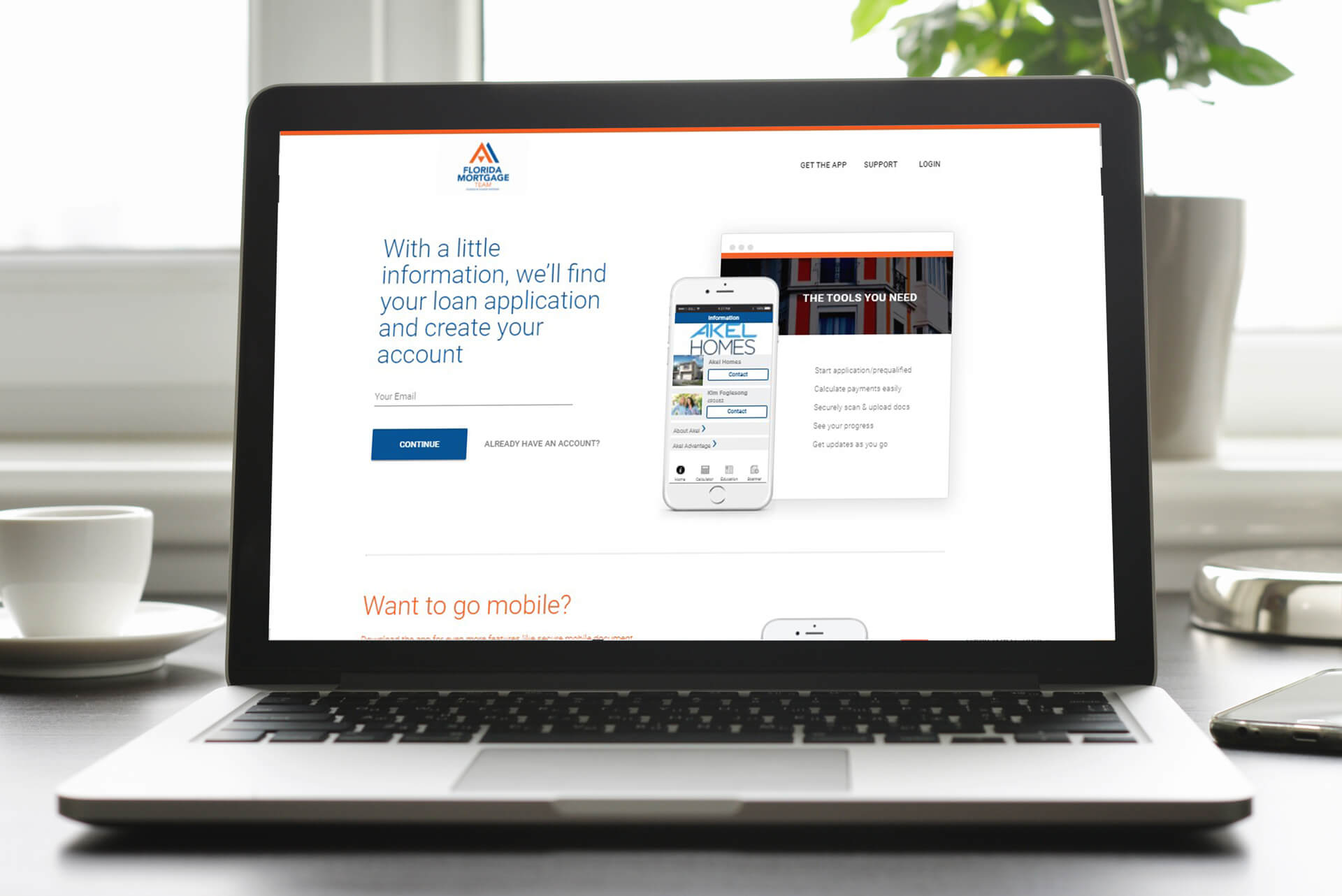 A sleek laptop showcases the Akel Homes loan application website interface, featuring seamless options for account creation and easy mobile access.