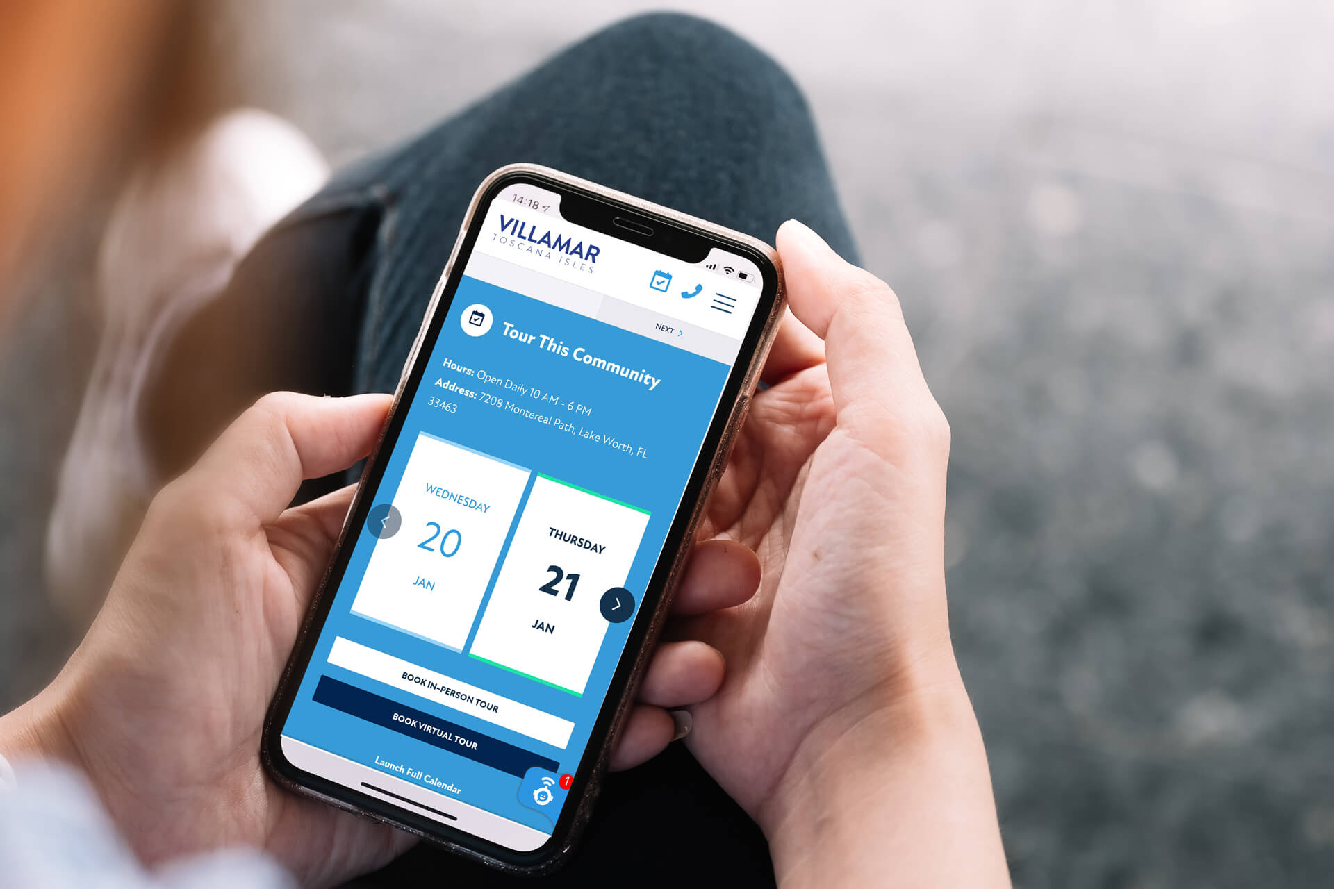 A person holds a smartphone showcasing a webpage for booking a community tour at Villamar by Akel Homes, with available dates on January 20 and 21.