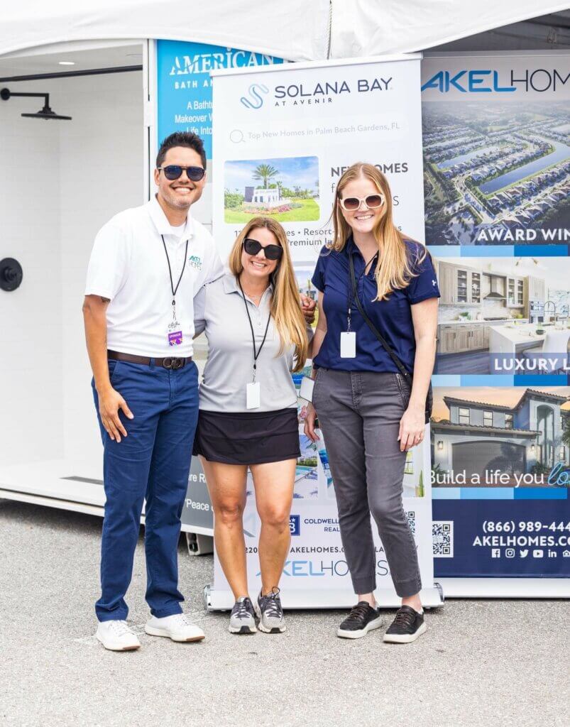 Akel Homes team members stand and pose for a photo at the ArtiGras event in Palm Beach Gardens.