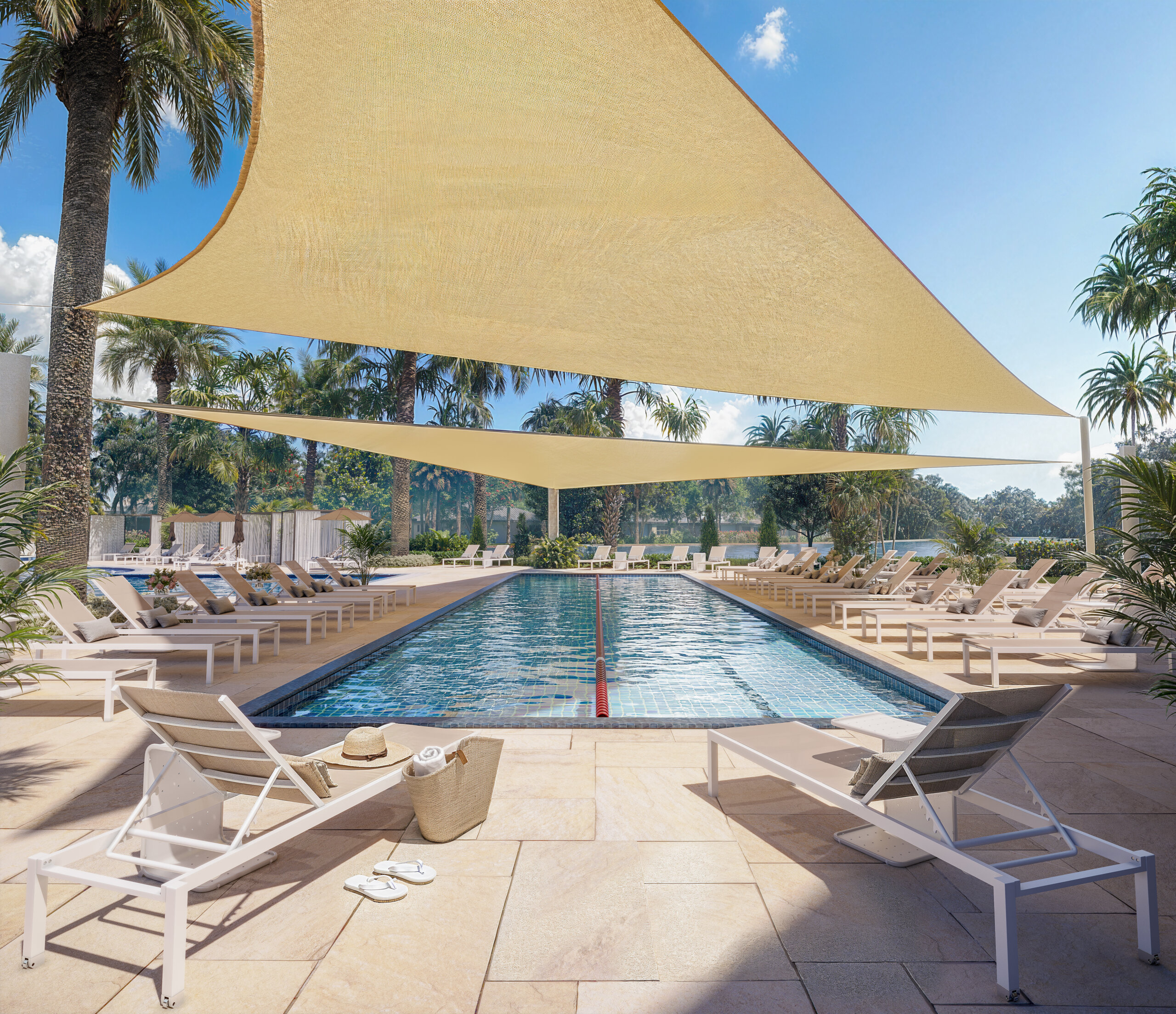 Rectangular outdoor swimming pool with sunshades above, surrounded by lounge chairs and palm trees on a sunny day.