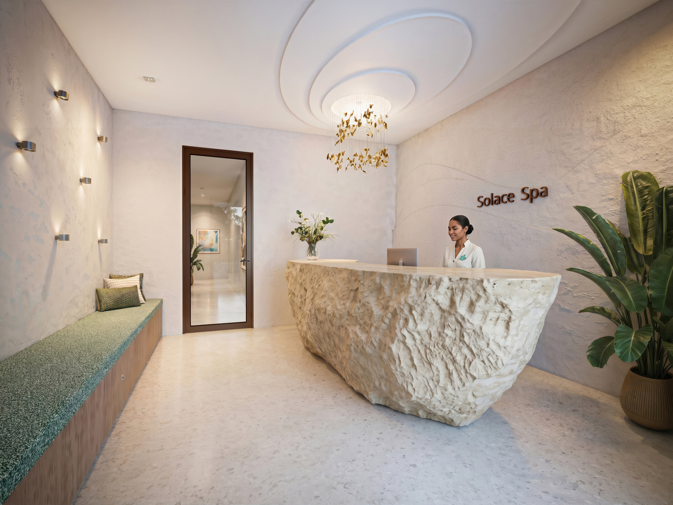 Reception area of Solace Spa at Club Catalina features a stone desk, a staff member seated, a green bench, potted plants, and decorative lighting. Walls and flooring are light-toned with minimalist decor, creating a serene ambiance reminiscent of the tranquil Catalina Palms.