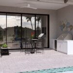 Modern outdoor patio with a dining table, chairs, grill, potted plants, and wall art beside a pool, with sliding glass doors reflecting palm trees.