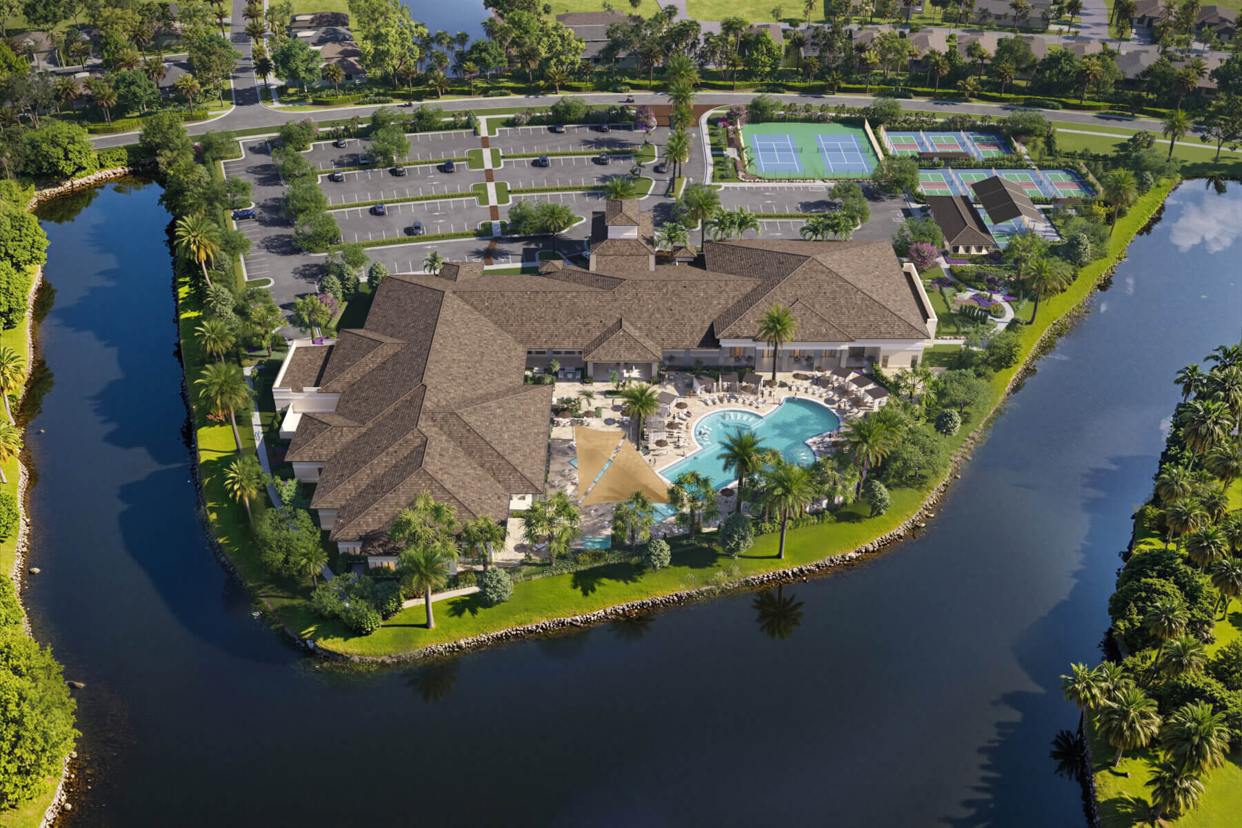 Aerial view of a large clubhouse with swimming pools, outdoor seating, tennis courts, and parking lot, surrounded by water and landscaped greenery.